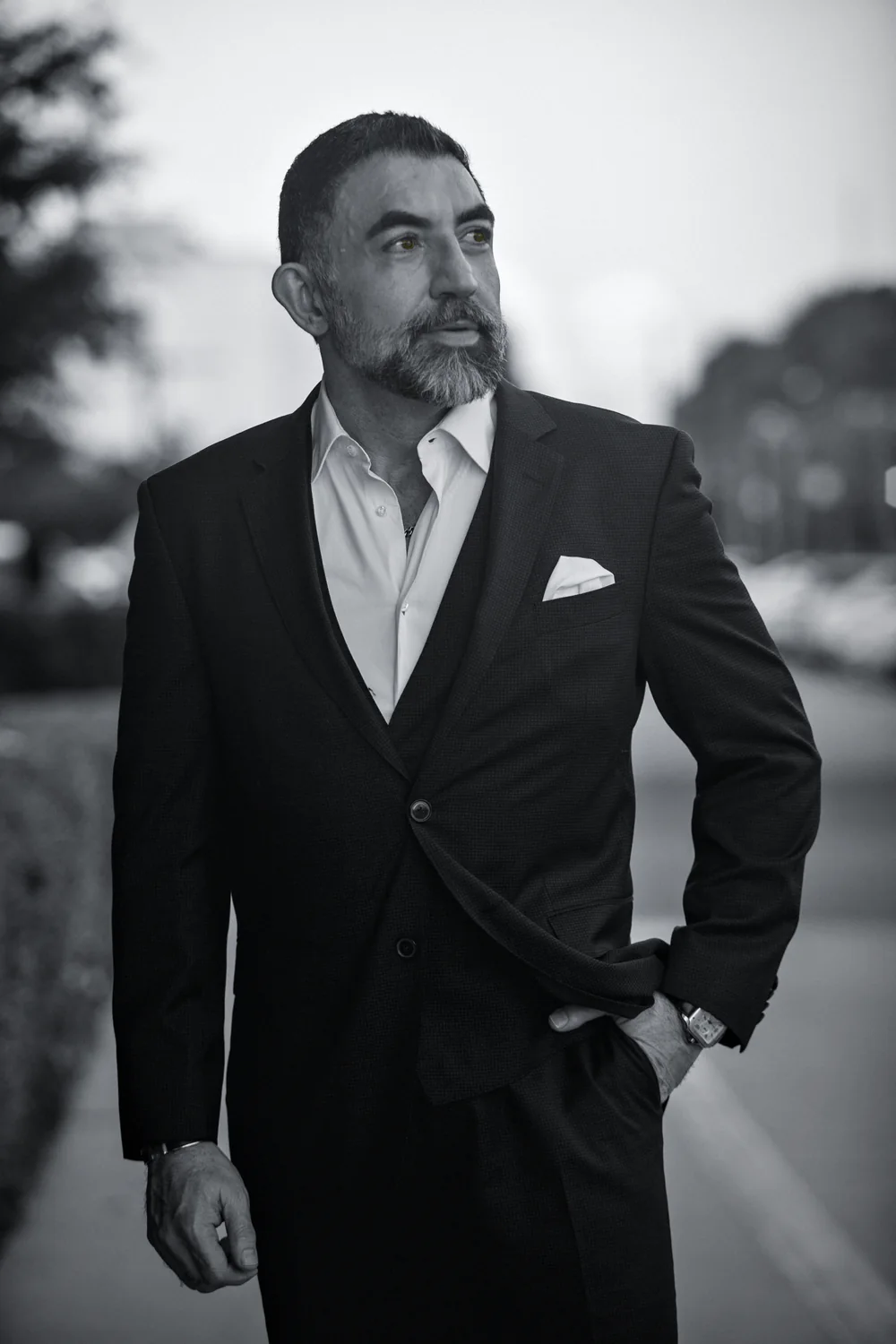 Houman Farzian in a dark suit on a Houston street at sunset, black and white